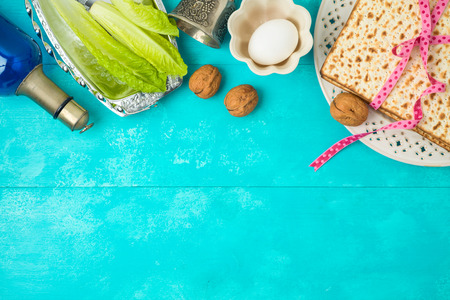 Jewish holiday Passover background with matzo, seder plate and wine on wooden table. Top view from...