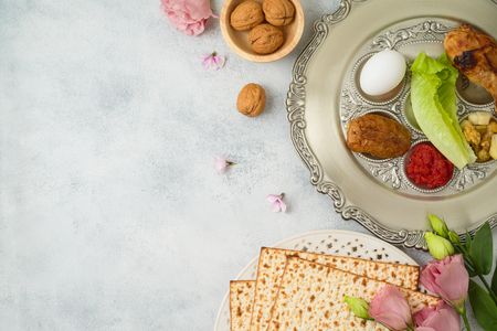 Jewish holiday Passover background with matzo, seder plate and spring flowers. Top view from above. Flat layの写真素材