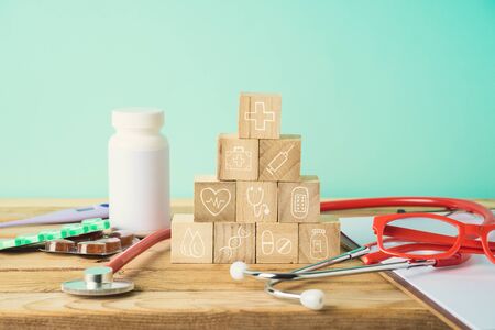 Healthcare and medical insurance concept with wooden blocks and medical icons on wooden tableの写真素材