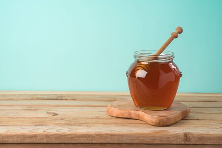 Jewish holiday Rosh Hashana background with honey jar on wooden tableの写真素材