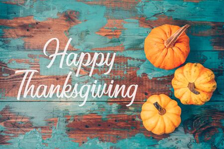 Happy Thanksgiving greeting card with pumpkin over wooden background. top view from aboveの写真素材