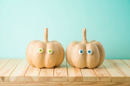 Halloween holiday concept with cute funny pumpkin decor on wooden tableの写真素材