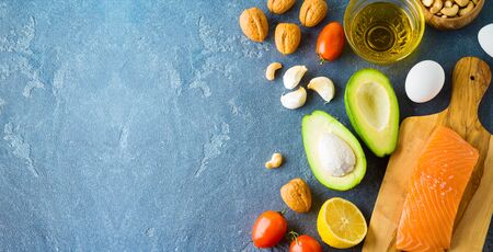 Ketogenic low carbs diet concept. Healthy eating and dieting with salmon fish, avocado, eggs and nuts. Top view from aboveの写真素材