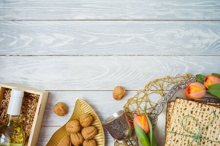 Jewish holiday Passover background with matzo, seder plate, wine and tulip flowers on wooden table. Top view from above.の写真素材