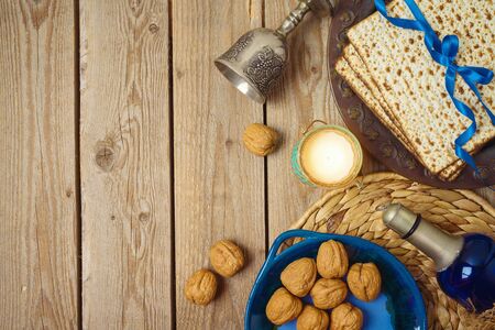 Jewish holiday Passover background with matzo, seder plate and wine on wooden table. Top view from...