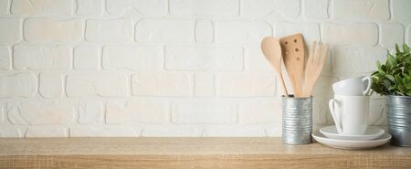 Kitchen background with dishware, utensils, cup, plate and plant on wooden shelfの写真素材