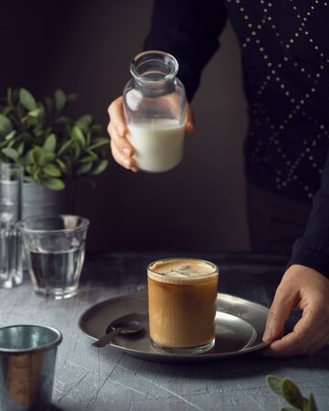 Cold coffee drink with milk over dark backgroundの写真素材