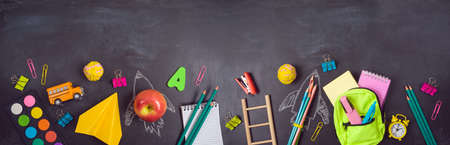 Back to school background with bag backpack, rocket sketch and school supplies over chalkboard. Top...