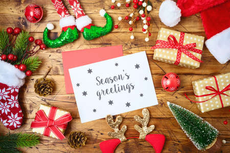 Christmas holiday greeting card or newsletter mock up template with decorations and ornaments on wooden tableの写真素材