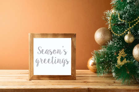 Christmas holiday photo frame mock up template with Christmas tree on wooden tableの写真素材
