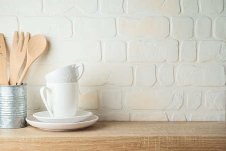 Kitchen background with dishware, utensils, cup and plate on wooden shelf