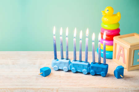 Jewish holiday Hanukkah concept with cute menorah on wooden table. Nursery decor and children room backgroundの写真素材