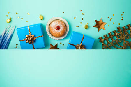 Jewish holiday Hanukkah banner design with menorah, sufganiyah, gift box and spinning top over blue...