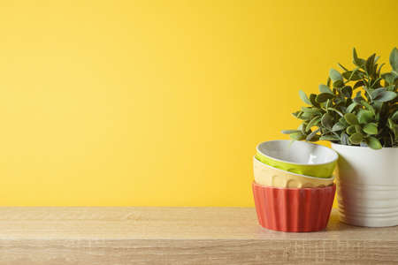Kitchen interior background with plant and colorful bowls on wooden shelfの写真素材