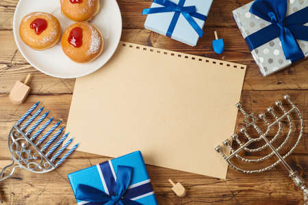 Jewish holiday Hanukkah background with traditional donuts, menorah and gift boxの写真素材