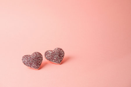 Valentine's day minimal concept with glitter heart shapes over pink backgroundの写真素材