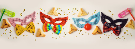 Jewish holiday Purim celebration background with traditional cookies and carnival maskの写真素材