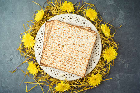 Jewish holiday Passover concept with matzah, seder plate and golden decorations on dark backgroundの写真素材