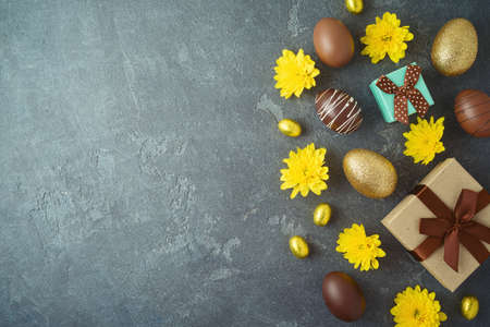 Easter holiday concept with golden Easter eggs and gift box on dark backgroundの写真素材