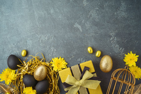 Easter holiday concept with golden Easter eggs and gift box on dark backgroundの写真素材