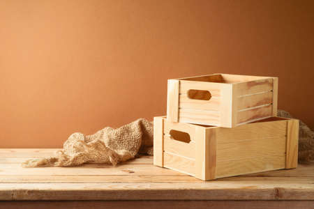 Empty wooden box on rustic table with sackcloth over  wall  background.  Harvest mock up for design and product display.の写真素材