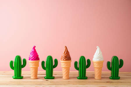 Summer holidays concept with toy ice cream and cactus on wooden tableの写真素材