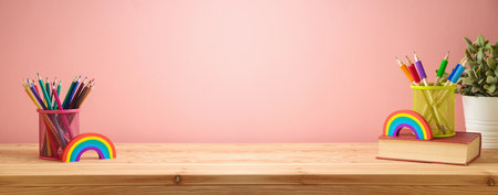 Back to school background with colorful pencils, book and rainbow on wooden table. Diversity and inclusion conceptの写真素材