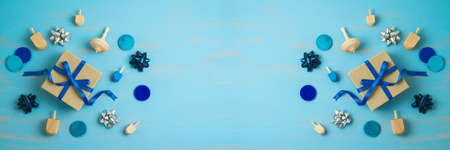 Jewish holiday Hanukkah  banner  with gift box and spinning top on blue background. Top view with...