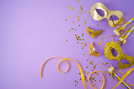 Carnival or mardi gras concept with golden carnival masks on violet background. Top view with copy spaceの写真素材