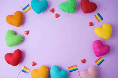 Rainbow heart shapes and rainbow flag on violet background. Happy Valentines day, inclusiveness and...