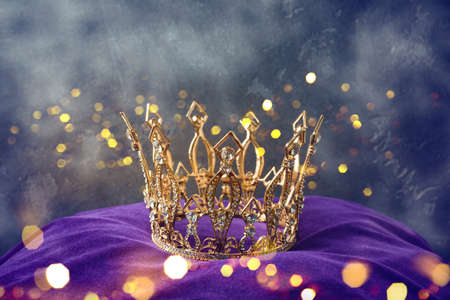 Golden queen crown over mysterious dark background. Mythical or fantasy world conceptの写真素材