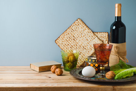 Jewish holiday Passover celebration concept with wine, matzah and seder plate on wooden table over...