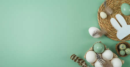 Easter holiday celebration concept with white eggs and decoration on green background. Banner template, top view, flat layの写真素材
