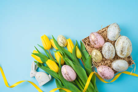 Easter holiday composition with Easter golden eggs and yellow  tulip flowers. Top view, flat lay...