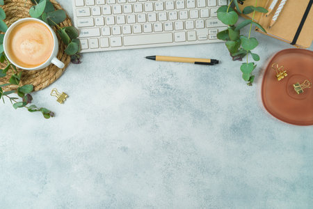 Modern desk with computer keyboard, eco friendly stationary and eucalyptus branches. Sustainable lifestyle concept. Top view, flat layの写真素材