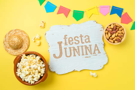 Festa Junina party background with popcorn, peanuts and wooden board. Brazilian summer harvest festival concept. Top view, flat layの写真素材