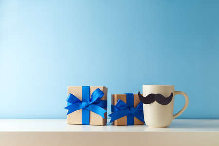 Father's day concept with coffee cup, mustache and gift box over blue backgroundの写真素材