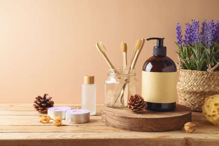 Body care bottle and eco friendly toothbrush for mock up packaging design on wooden table over beige backgroundの写真素材
