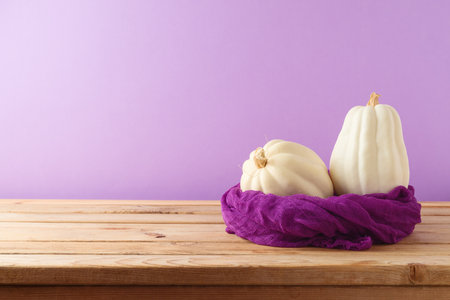 White pumpkin on wooden table over purple background.  Autumn still lifeの写真素材