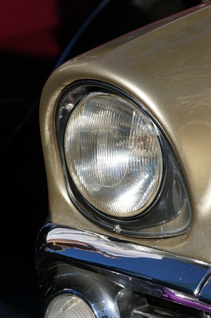 Closeup of a front headlight on a restored 1960's car