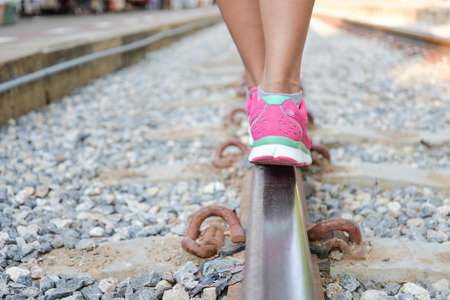 Woman walking on railroad tracksの写真素材