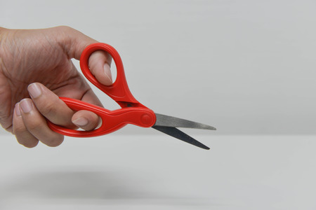 Hand holding the red scissorsの写真素材