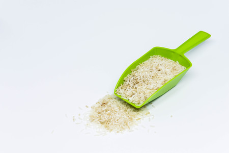 Green measuring spoon with rice on the white screenの写真素材