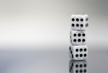 Macro of three dice stack with six points and reflectionの写真素材