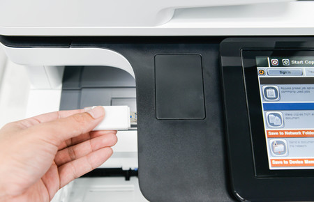 Human hand is using the USB drive to printer to printing the documentの写真素材