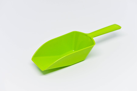Green plastic measuring spoon on the white backgroundの写真素材