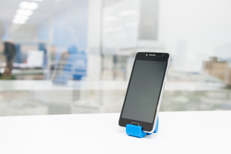 Black mobile phone on phone holderの写真素材