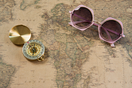 Compass and Pink eyeglasses on the vintage map for traveling conceptの写真素材
