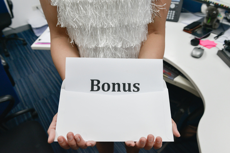 Business woman is showing the bonus from envelopeの写真素材
