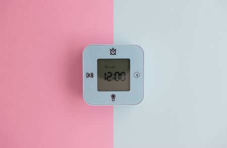 Minimal flat lay concept of blue mini digital alarm clock with LED screen on the colorful pastel background - top viewの写真素材